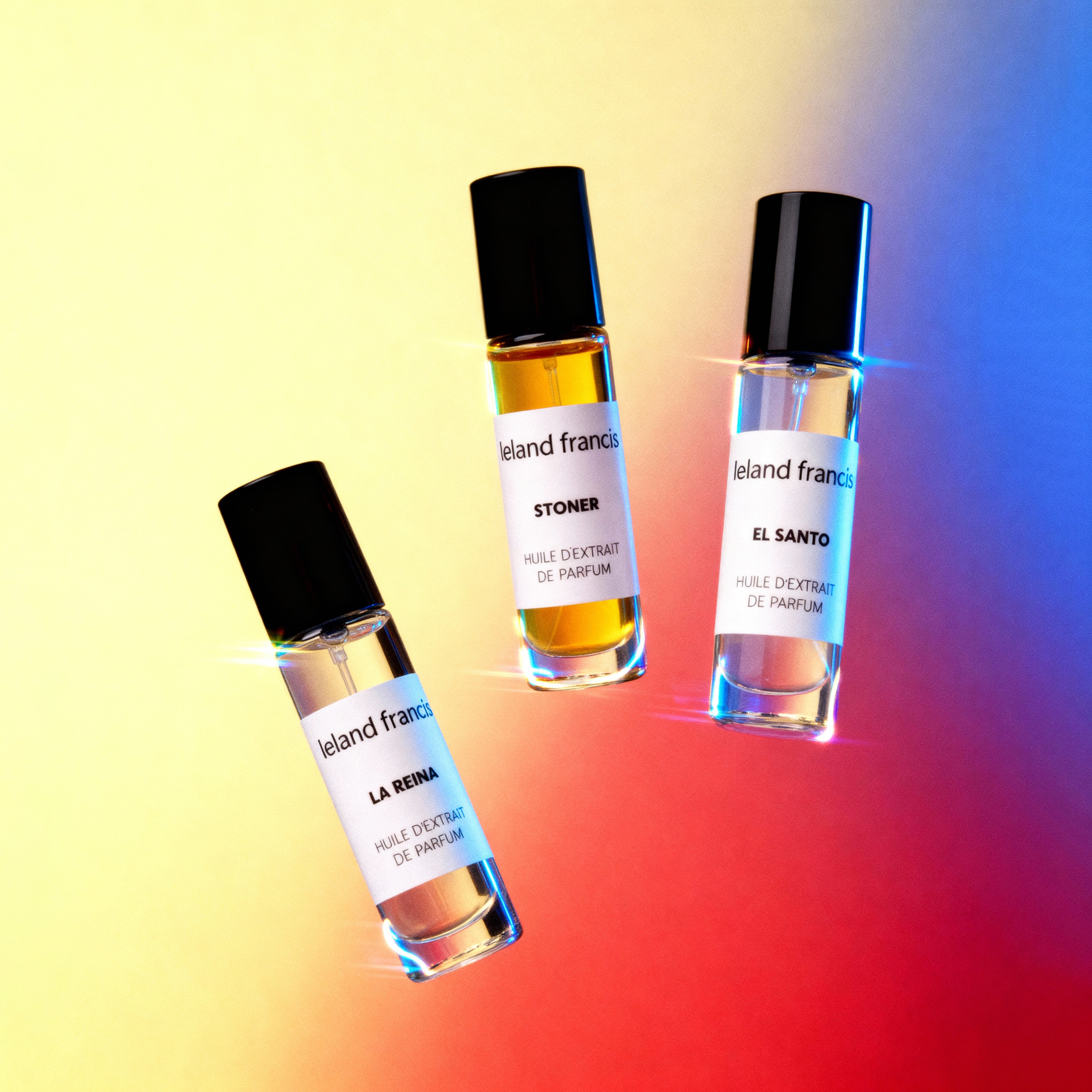 Three small perfume bottles with labels on a gradient background