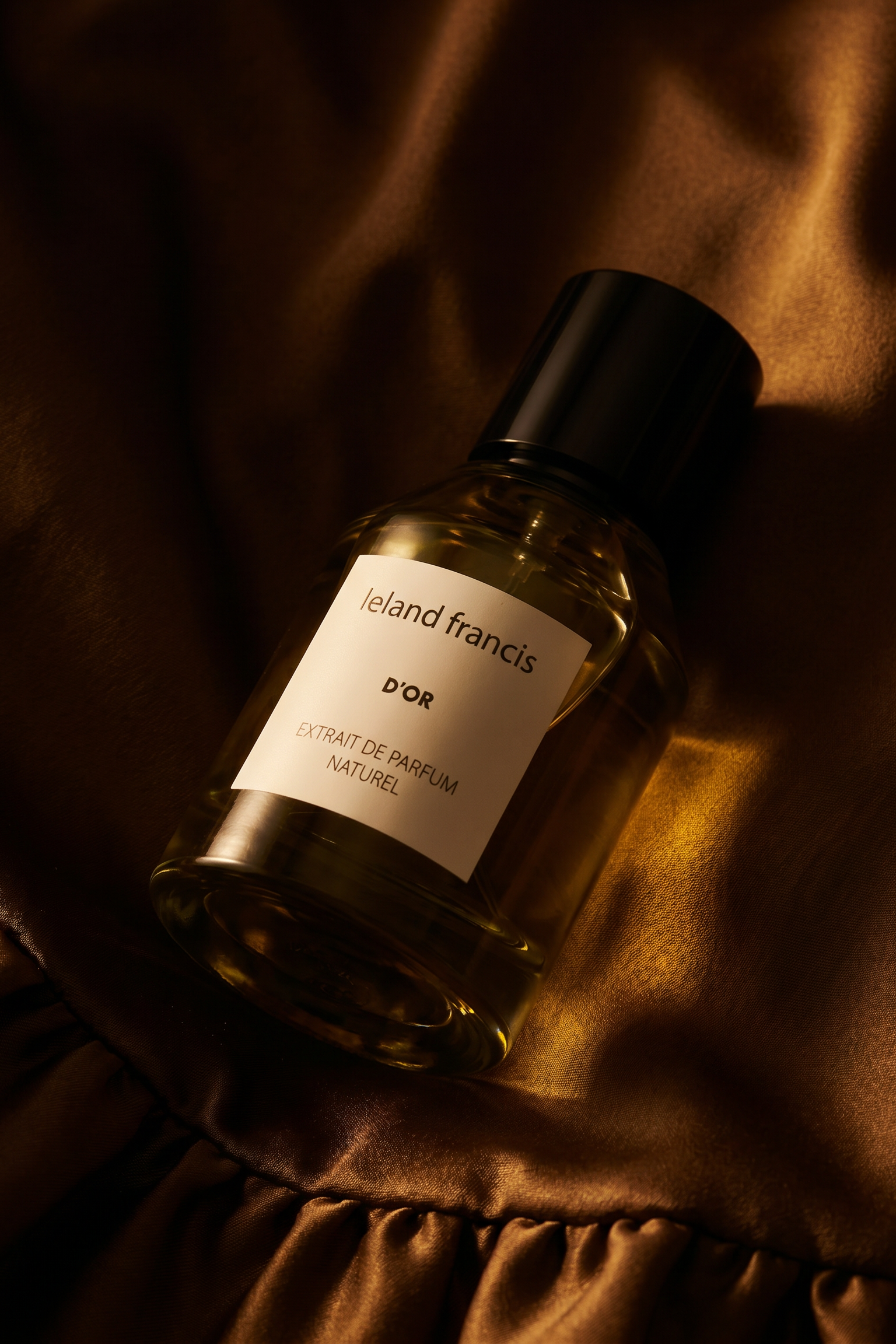 Perfume bottle labeled lelend francis D'or' on a textured brown surface