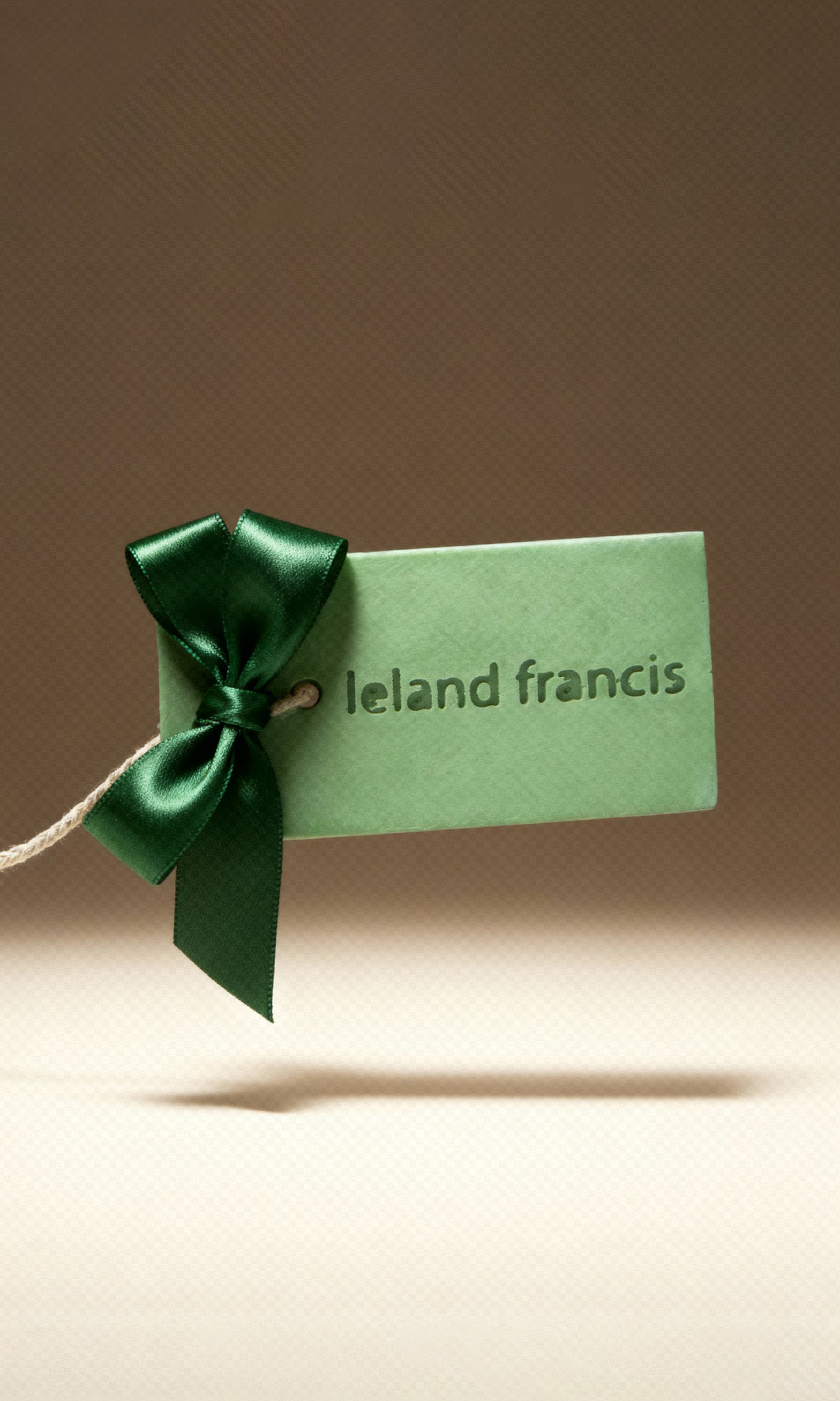 Green gift tag with a bow on a brown background