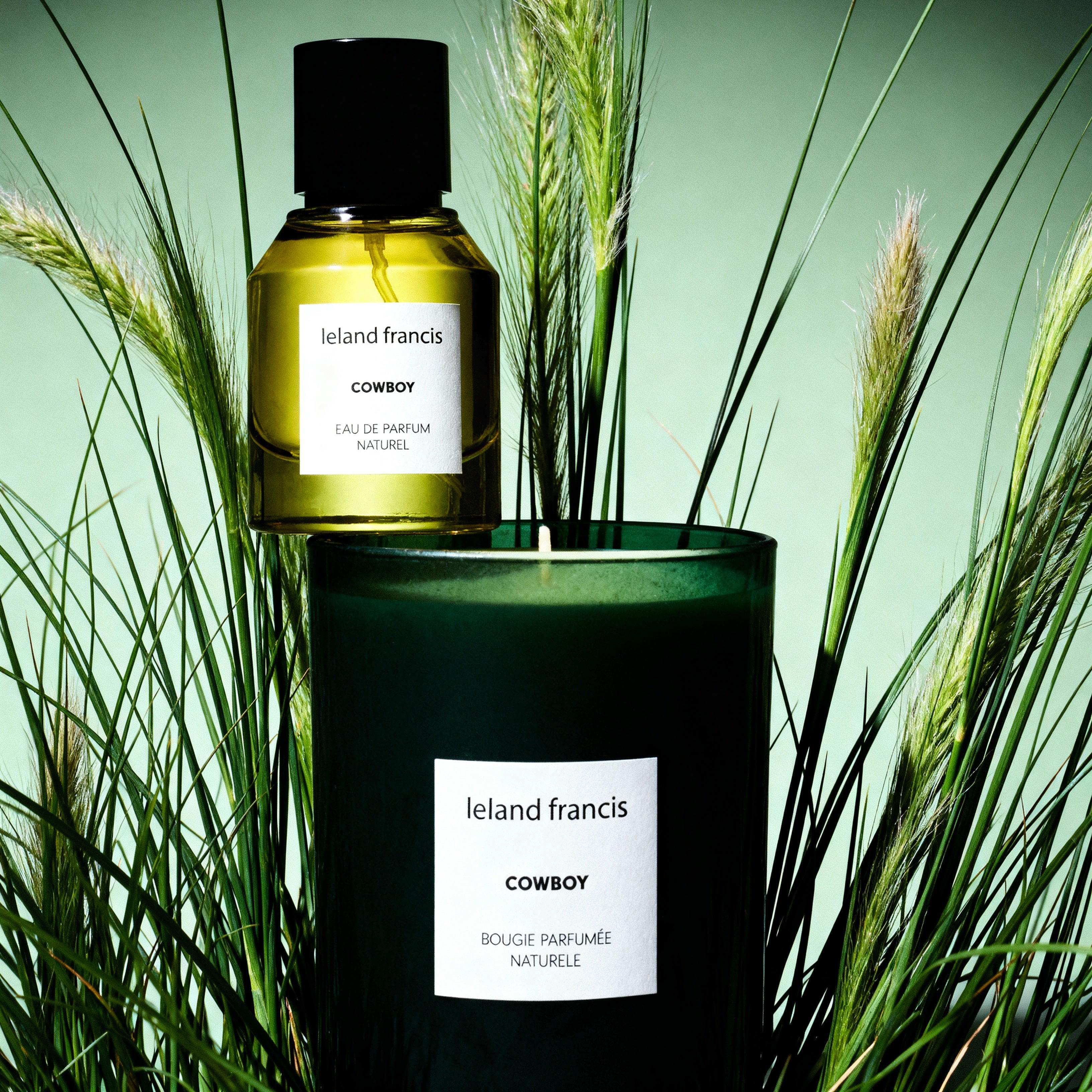 Ireland Francis Cowboy candle and bottle surrounded by tall grasses on a green background