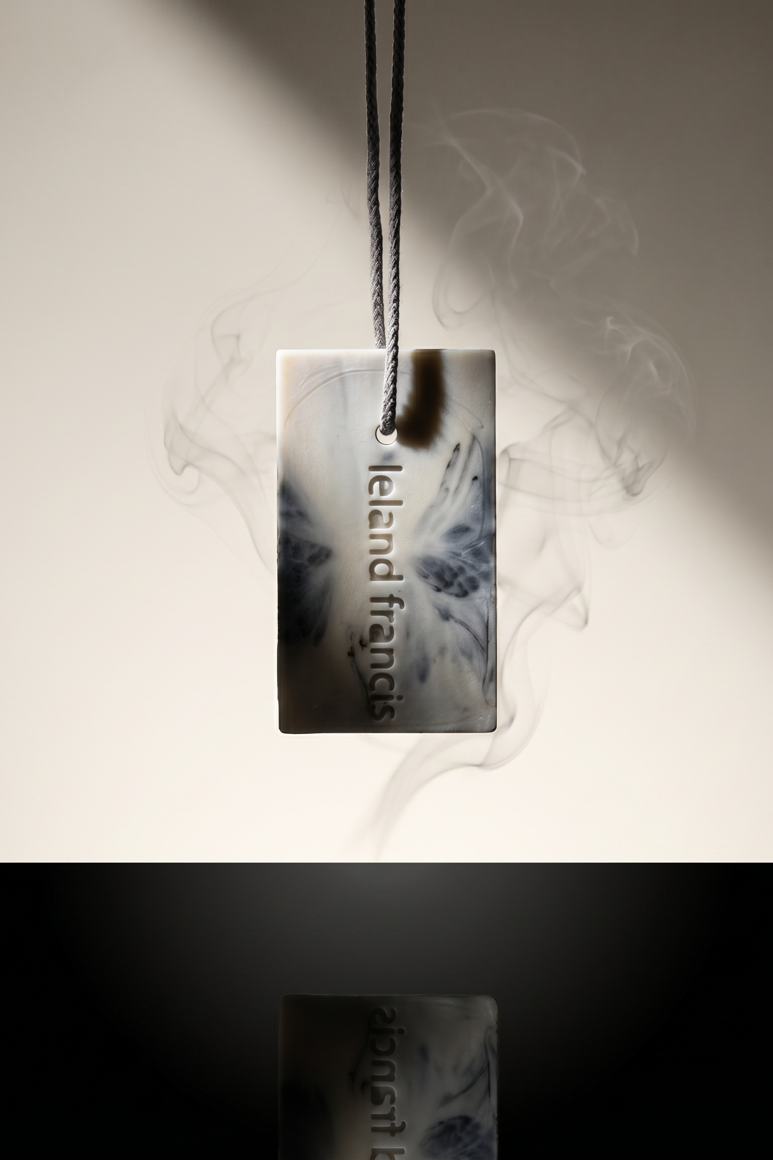 Marble-textured soap on rope with 'Leland Francis' branding on a dark background